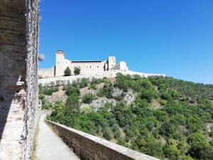 ein Schloss auf einem Hügel mit einer Mauer in der Unterkunft Posto del Sole in Spoleto