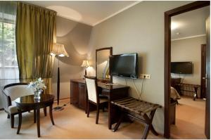 a hotel room with a television and a desk with a mirror at Greenway Park Hotel in Obninsk
