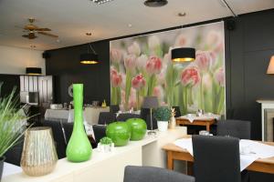 a restaurant with green vases and tables and chairs at Hotel Pflug in Ottenhöfen