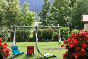 a group of chairs sitting in the grass at Bauernhof Waldesruh in Tannheim