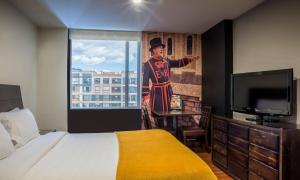 a hotel room with a bed and a painting of a man at Hotel Santa Barbara Real in Bogotá