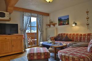 a living room with a couch and a tv at Bauernhof Waldesruh in Tannheim