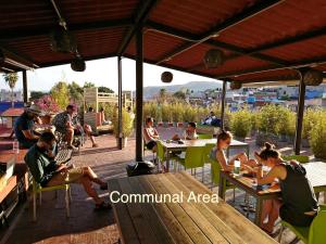 een groep mensen die aan tafels op een terras zitten bij Casa Angel Hostel in Oaxaca City