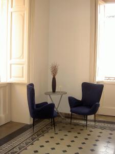 um quarto com duas cadeiras, uma mesa e um vaso em ZAGARA My Home em Vittoria