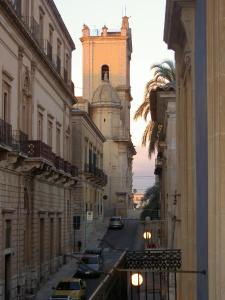 eine Stadtstraße mit einem Gebäude und einem Uhrturm in der Unterkunft ZAGARA My Home in Vittoria