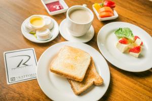 a white plate topped with a sandwich and a cup of coffee at Hotel Santa Barbara Real in Bogotá