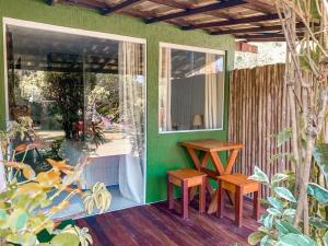 a room with a green wall with two benches and a window at Pousada Cheiro Verde Noronha in Fernando de Noronha