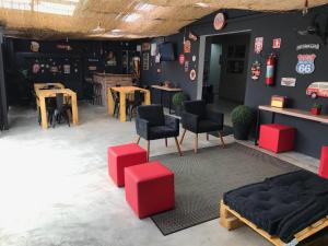 a room with red and black chairs and tables at Visto Hostel in Sao Paulo