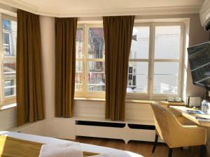 a room with windows and a desk with a computer at Merveilleux in Ghent