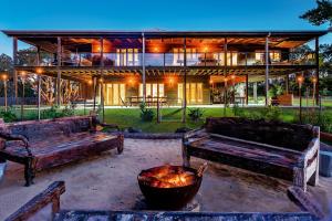 a building with two benches in front of a fire pit at Tranquilo Beach House in Woolgoolga