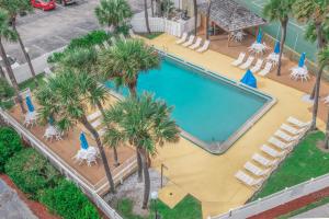 an overhead view of a swimming pool with chairs and palm trees at GetAways at Turtle Reef Club in Jensen Beach