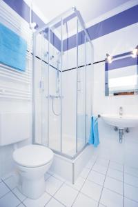 een badkamer met een douche, een toilet en een wastafel bij Hotel Weitblick Bielefeld in Bielefeld