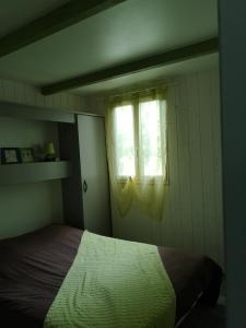 a bedroom with a bed and a window at Chalet Du Bas-Mée in Le Mée