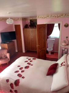a bedroom with a large bed with roses on it at Lower Balwill in Buchlyvie