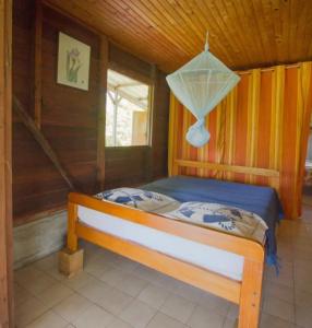 ein Schlafzimmer mit einem Bett in einer Holzhütte in der Unterkunft Chalet mer et montagne in Sainte-Anne