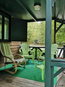 a group of chairs sitting on a porch at Chalet Du Bas-Mée in Le Mée