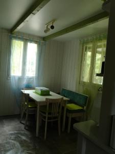 Habitación con mesa, sillas y ventanas. en Chalet Du Bas-Mée, en Le Mée