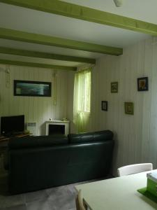 a living room with a black couch and a window at Chalet Du Bas-Mée in Le Mée