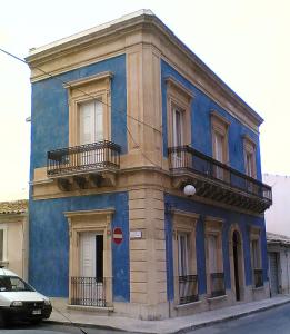 un edificio blu con due balconi su una strada di ZAGARA My Home a Vittoria