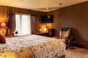 a bedroom with a bed and a brick wall at Shane Acres Country Inn in Juneau