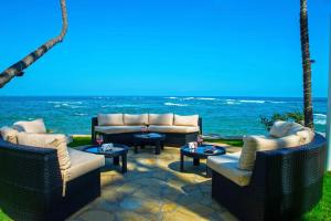 un patio con sillas, mesas y el océano en Velero Beach Resort en Cabarete