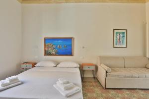 a bedroom with a bed and a couch at Storie di Palermo in Palermo