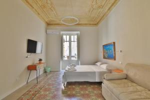 a living room with a bed and a couch at Storie di Palermo in Palermo