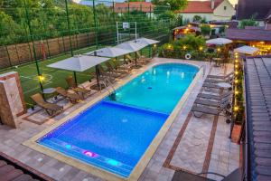 an overhead view of a swimming pool with chairs and umbrellas at Conacul Ambient in Cristian