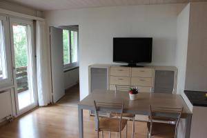 a dining room with a table with chairs and a television at Parsennblick in Davos