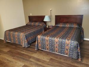 A bed or beds in a room at Battlefords Inn