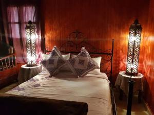 um quarto com uma cama com duas luzes em Kasabah Senhaji em Moulay Idriss