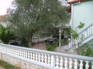 einen weißen Zaun vor einem Haus mit einem Baum in der Unterkunft Apartment Mare - with terrace in Pakoštane