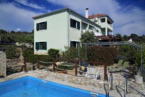 una casa con piscina frente a una casa en Apartment Toni - with pool and view, en Maslinica