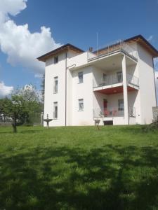 a white building with a grassy field in front of it at Villa Emilia in Castronno