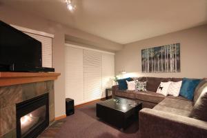 a living room with a couch and a fireplace at Sunpath Condos by Whistler Retreats in Whistler