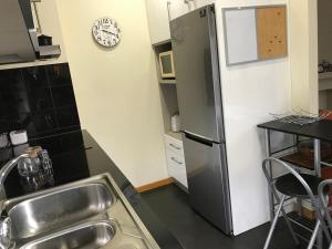een keuken met een roestvrijstalen koelkast en een wastafel bij Viriato Central House in Viseu