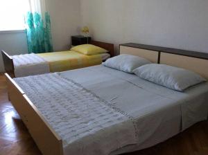 a bedroom with two beds and a window at Apartment Sova - 20m from beach in Postira