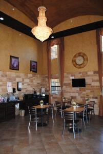 a restaurant with tables and chairs and a clock on the wall at Scottish Inns Fort Worth in Fort Worth