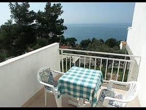 d'une table et de chaises sur un balcon donnant sur l'océan. dans l'établissement Apartments Vedra- free parking and close to the beach, à Baška Voda