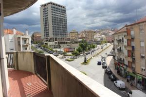 een balkon met uitzicht op een stadsstraat met gebouwen bij Viriato Central House in Viseu