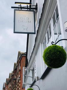 a sign hanging on the side of a building at The Old Drum in Petersfield