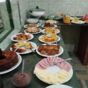 a table full of different types of food on plates at Hospedaria de Maria in Tiradentes