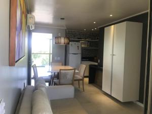 a living room with a couch and a kitchen with a table at Flat Beach Class Muro Alto 4307 in Porto De Galinhas