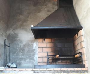 um forno de tijolos com uma placa de fogão com fumo em La Bodega de Puy em Graus