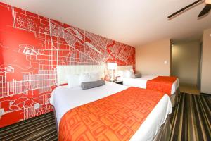 a hotel room with two beds and a red wall at Howard Johnson by Wyndham Winnipeg West in Winnipeg