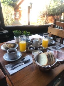 stół ze śniadaniem składającym się z chleba i soku pomarańczowego w obiekcie Solares Del Sur w mieście El Calafate