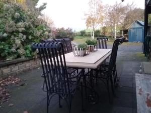 a table with chairs and plants on a patio at Robin's Nest B&B in Wilmot