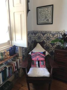 a room with a chair with a pillow on it at Pensão José das Hortas in Costa Nova