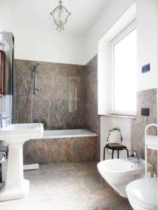 La salle de bains est pourvue d'un lavabo, d'une baignoire et de toilettes. dans l'établissement Villa Emilia, à Castronno
