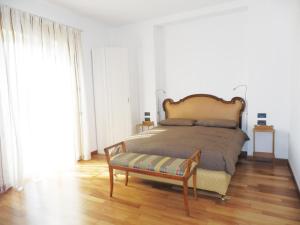 a bedroom with a bed with a bench in it at Villa Emilia in Castronno